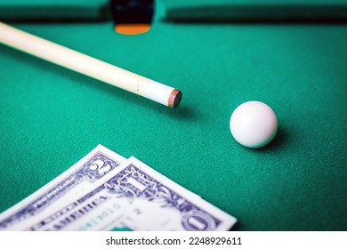 Gambling ardor game.Dollar cash and white billiard ball.Dollar paper banknotes on the game table.Selective focus. - Shutterstock ID 2248929611