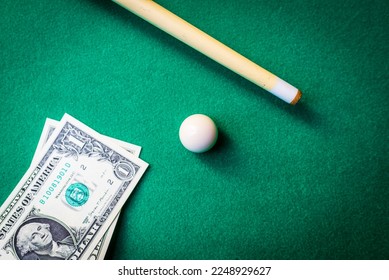 Gambling ardor game.Dollar cash and white billiard ball.Dollar paper banknotes on the game table.Selective focus. - Shutterstock ID 2248929627