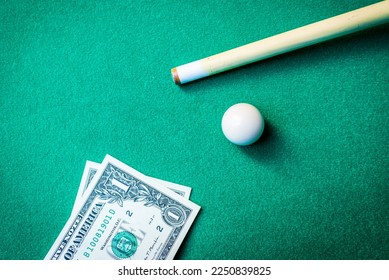 Gambling ardor game.Dollar cash and white billiard ball.Dollar paper banknotes on the game table.Selective focus. - Shutterstock ID 2250839825