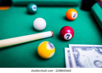Gambling ardor game.Money and multicolored billiard balls with numbers.Dollar paper banknotes on the game table.Selective focus. - Shutterstock ID 2248045663
