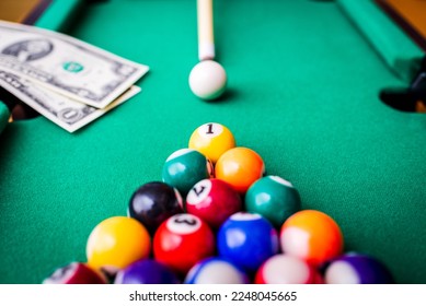 Gambling ardor game.Money and multicolored billiard balls with numbers.Dollar paper banknotes on the game table.Selective focus. - Shutterstock ID 2248045665