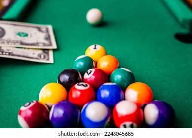 Gambling ardor game.Money and multicolored billiard balls with numbers.Dollar paper banknotes on the game table.Selective focus. - Shutterstock ID 2248045685