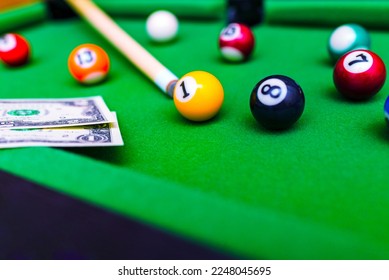 Gambling ardor game.Money and multicolored billiard balls with numbers.Dollar paper banknotes on the game table.Selective focus. - Shutterstock ID 2248045695