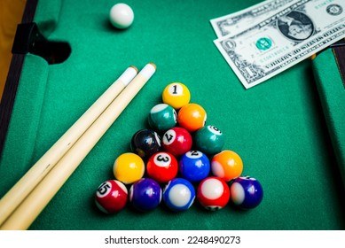 Gambling ardor game.Money and multicolored billiard balls with numbers.Dollar paper banknotes on the game table.Selective focus. - Shutterstock ID 2248490273
