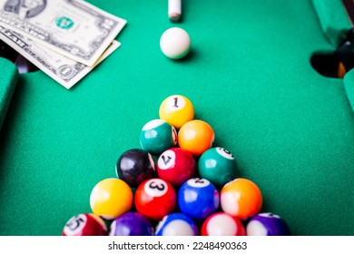 Gambling ardor game.Money and multicolored billiard balls with numbers.Dollar paper banknotes on the game table.Selective focus. - Shutterstock ID 2248490363