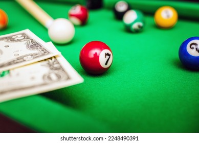 Gambling ardor game.Money and multicolored billiard balls with numbers.Dollar paper banknotes on the game table.Selective focus. - Shutterstock ID 2248490391