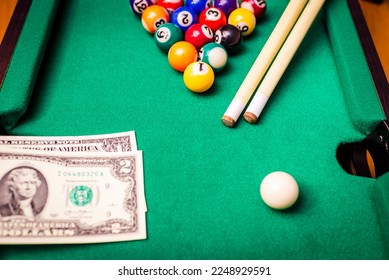 Gambling ardor game.Money and multicolored billiard balls with numbers.Dollar paper banknotes on the game table.Selective focus. - Shutterstock ID 2248929591