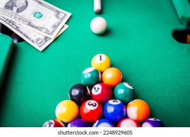 Gambling ardor game.Money and multicolored billiard balls with numbers.Dollar paper banknotes on the game table.Selective focus. - Shutterstock ID 2248929605