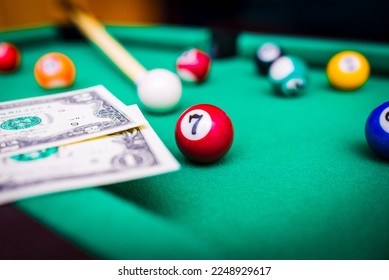 Gambling ardor game.Money and multicolored billiard balls with numbers.Dollar paper banknotes on the game table.Selective focus. - Shutterstock ID 2248929617