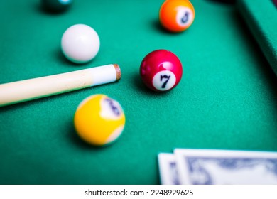Gambling ardor game.Money and multicolored billiard balls with numbers.Dollar paper banknotes on the game table.Selective focus. - Shutterstock ID 2248929625