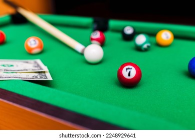 Gambling ardor game.Money and multicolored billiard balls with numbers.Dollar paper banknotes on the game table.Selective focus. - Shutterstock ID 2248929641