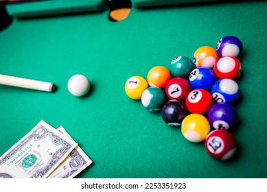 Gambling ardor game.Money and multicolored billiard balls with numbers.Dollar paper banknotes on the game table.Selective focus. - Shutterstock ID 2253351923