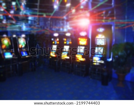 Gambling blurred background. Row of digital-based slot machines inside a casino, gambling club interior out of focus. Game of chance abstraction