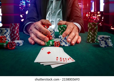Gambling concept. Close up of Poker Player male hand Winning Royal Flush at casino, gambling club. Сasino chips or Casino tokens,  dice, poker cards, gambling man lucky guy, games of chance. - Shutterstock ID 2158003693