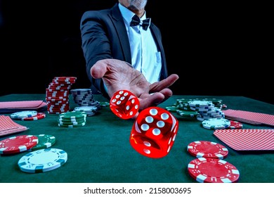 Gambling concept. Close up of Poker Player male hand throwing dice at casino, gambling club. Сasino chips or Casino tokens, poker cards, gambling man lucky guy spending time in games of chance.