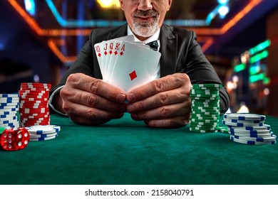 Gambling concept. Close up of Poker Player male hand Winning Royal Flush at casino, gambling club. Сasino chips or Casino tokens,  dice, poker cards, gambling man lucky guy, games of chance. - Shutterstock ID 2158040791