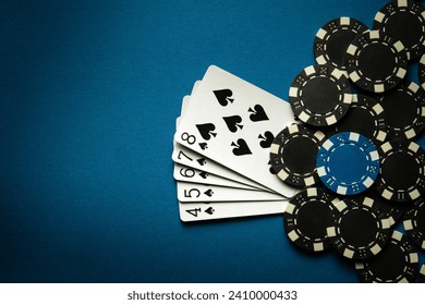 A gambling game of poker with a winning combination of straight flush. Cards with chips on a blue table in a poker club. Advertising space. - Powered by Shutterstock