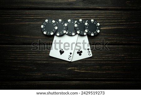 A gambling and popular poker game with a winning combination of one pair. Chips and cards on a dark vintage table in a poker club.