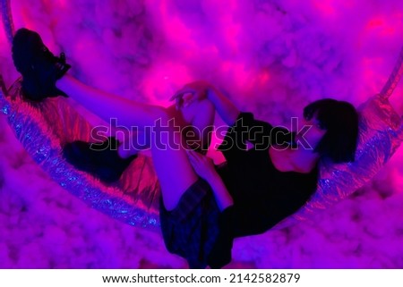 Game with augmented reality, technology of the future. Beautiful young woman with short black hair, in a fashionable stylish skirt near the clouds