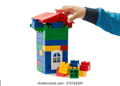 Game constructor and the hand of of the child isolated on white background.This is not a Lego, given manufacturer, different form and fixation, size