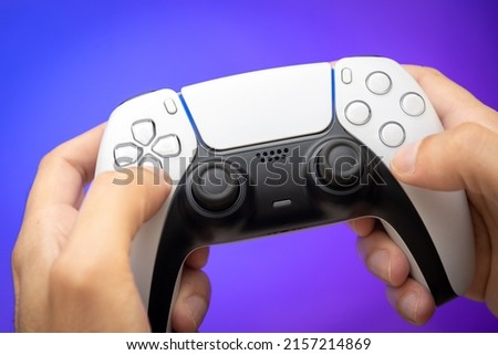 Game controller on man hands with purple background.