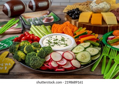 Game Day Display Of Football Tailgate Themed Party Food With Vegetable Platter With Ranch Dressing Dip, Meat, Cheese And Cracker Tray With Spinach Artichoke Dip