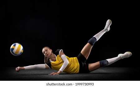 Game In Defense. Female Professional Fit Volleyball Player With Ball Isolated On Black Studio Background. The Athlete, Exercise, Action, Sport, Training, Fitness Concept. The Girl In Motion.