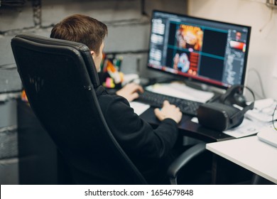 Game Designer Sitting On Chair With Computer Desktop Near Virtual Reality Goggles, Vr Glasses Headset