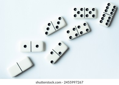 The game of dominoes is a table game involving rectangular pieces with dots that represent numbers. The objective is to match tiles with matching numbers. Photo with white background. - Powered by Shutterstock