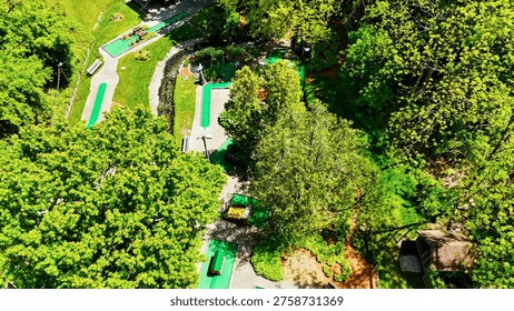 A game of mini golf is underway between two ladies on a beautiful sunny summer day on an impeccable course.