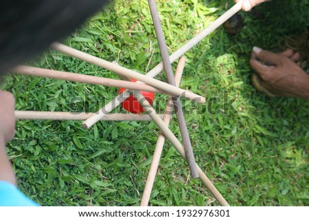 The game of moving small balls using wooden sticks requires hand balance and teamwork