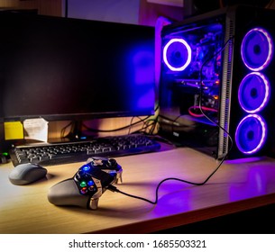 Game Pad On A Wooden Desk With Glass Pc Case On The Background