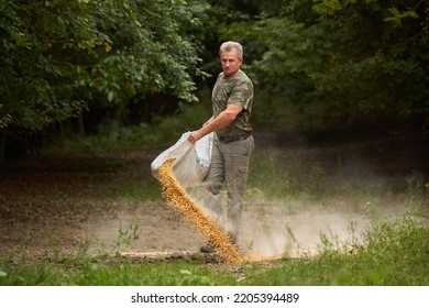 Game Ranger Spilling Maize On The Ground At Animals Feeding Spot