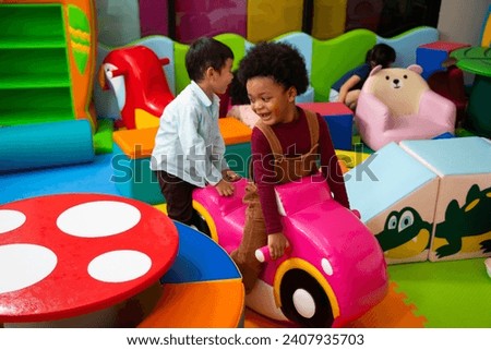 Game room. Kindergarten. African american little kid and diverse friends playing and enjoying time in childrens entertainment and play area