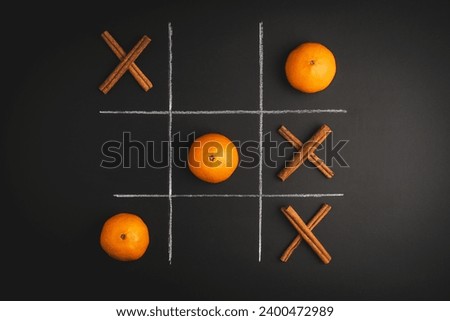 Game of Tic-tac-toe with cinnamon and tangerine on a black background
