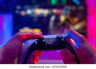 Gamepad In The Hands Of A Gamer On A Technological Background. Neon Lighting. Video Games Online With Friends, Winnings, Prizes, Fun Entertainment, Youth Culture, Virtual Reality.