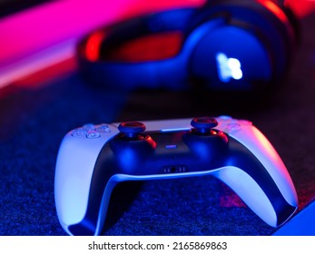 Gamepad And Headphones Close-up. Video Game Accessories. Isolated On Technological Background. Neon Lighting. There Are No People In The Photo. Advertising, Banner, Invitation.