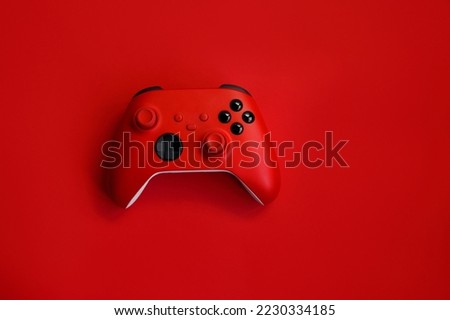 Gamepad on a red background. Game concept, esports, leisure, gaming industry, video games. Flat lay, top view