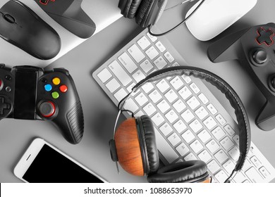 Gamepads, mice, headphones and keyboard on table - Shutterstock ID 1088653970