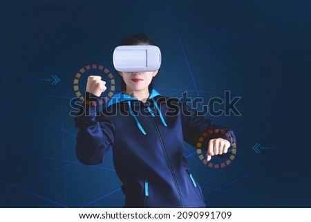 Gamer asian girl palying fighting game online with handsup touching icon in the air and wearing VR glasses or virtual reality glasses ,Virtual reality with esport concept
