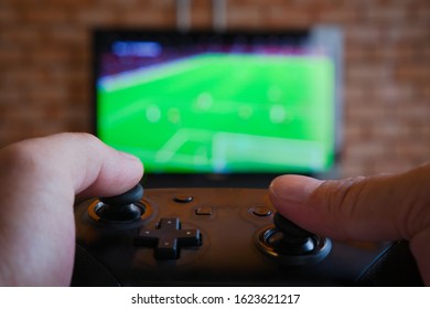 Gamer control the joy while playing football video games.