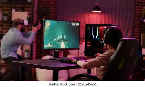 Gamer Girl Shocked After Losing Fast Paced Space Shooter While Boyfriend Is Enjoying Virtual Reality Role Playing Game At Home. Couple In Online Gaming Competition Using Pc And Vr Goggles.