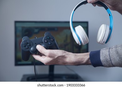 Gamer Holding Joystick And Headphones.