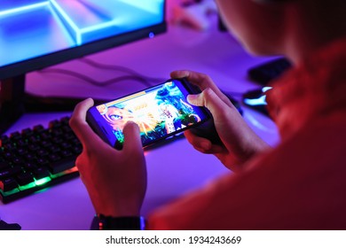Gamer playing online game on smart phone in dark room. e-Sport Games compilation and Internet Championship. - Shutterstock ID 1934243669