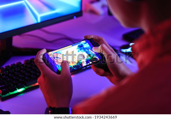 Gamer playing\
online game on smart phone in dark room. e-Sport Games compilation\
and Internet\
Championship.