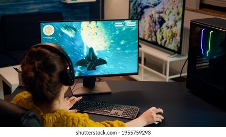 Gamer Playing Shooter Games With Other Players Late At Night During Gaming Championship. Pro Esport Team Player Streamer During E-game Tournament On Powerful RGB Computer, Using Streaming Technology