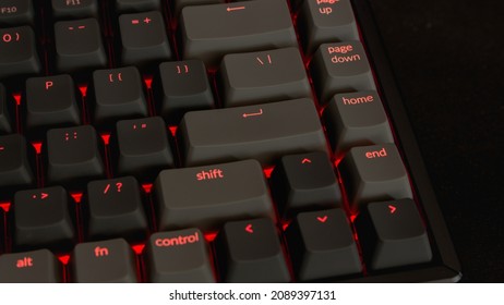 Gamer RGB Keyboard With The Color Red On A Black Mousepad