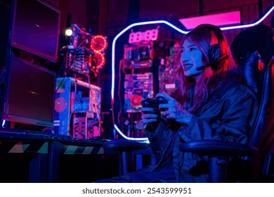 Gamer using joystick controller for virtual tournament plays online video game with computer neon lights, woman wear gaming headphones playing live stream esports games console gaming room