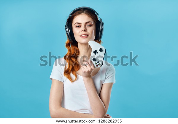 Gamer woman in headphones and with a joystick in
his hand                      
