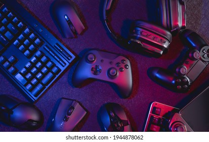 gamer work space concept, top view a gaming gear, mouse, keyboard, joystick, headset with rgb color on black table background. - Shutterstock ID 1944878062